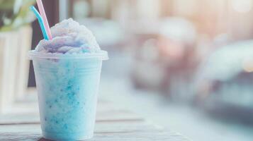 A blue milkshake with a straw sitting on a table photo