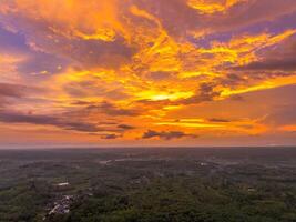 A colorful sunset over a forested area photo