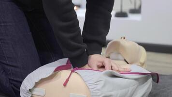 Hands practicing CPR chest compressions on dummy, first aid training session with clear focus on technique video