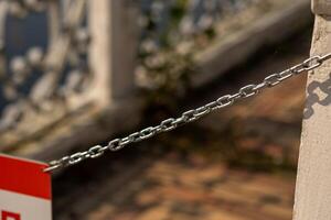 Details of a chain barrier at Peterhof revealing a glimpse of the historic architecture photo