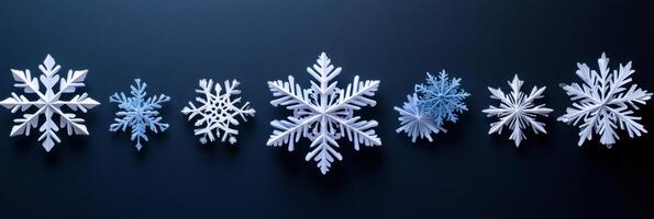Delicate handcrafted paper snowflakes in various designs rest on a dark surface, offering ample blank space for personal notes or messages. photo
