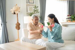 Senior couple exercise with lifting dumbbell for strength training at home photo