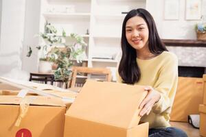 Smiling woman with cardboard boxes for moving to the new home photo
