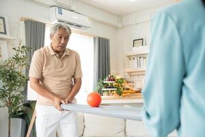 Elderly man playing rolling ball for practice balance and concentrate at home photo