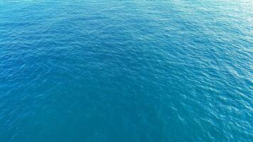 Blue serenity of the ocean waves gently lapping the shore under a clear sky on a calm summer afternoon photo