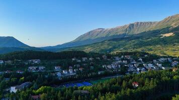 Captivating view of serene mountains and quaint village nestled in lush greenery during the golden hour photo