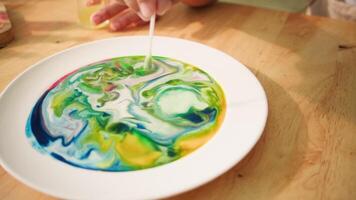 Swirling color patterns from milk and soap reaction in science activity video