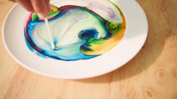 Dish soap breaks surface tension in milk during science experiment video