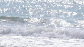 Sparkling ocean waves gently rolling on the shore in portugal video