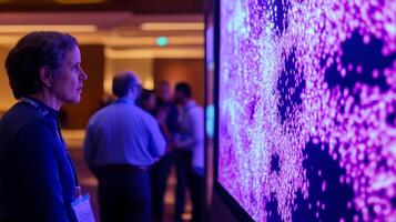 Scientist looking at large screen displaying big data visualization with purple particles simulating complex information analysis in a conference setting photo
