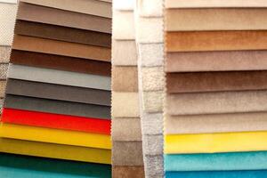 Catalog of textiles for the manufacture of upholstered furniture. Samples of multicolored fabrics. Choosing the color of the sofa. Background for the textile industry. photo
