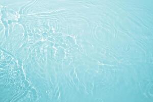 Background with clear blue water. Water background with small bubbles. transparent water surface with splashes and wave texture with ripples. Top view, a place to copy photo