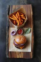 A wooden tray with burger, sweet potato fries spill from a handmade paper cone with visible pulp texture and ketchup. photo