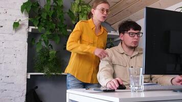 millennial man and woman in casual clothes using and computer while spending time at home, watching funny videos