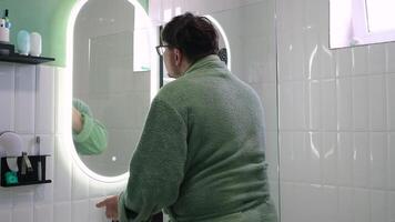 man applying cream for shaving in front of a Mirror in the bathroom video