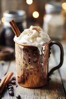 A weathered copper mug with coffee cocktail topped with homemade vanilla bean whipped cream and a cinnamon stick. photo