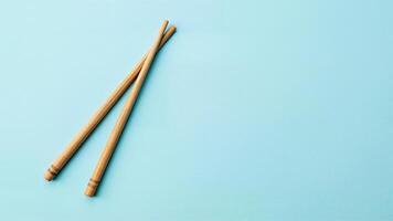Bamboo Asian Chopsticks Isolated on Blue Background photo