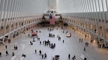 New York. US 05.04.2025 Wide interior view of Oculus transit hub in New York with American flag and people inside, Iconic white architectural space combines shopping and commuting in futuristic video