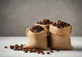 Three Burlap Sacks of Coffee Beans on Light Surface photo