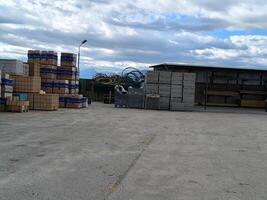 Stacks of building materials and tools under a cloudy sky in a construction yard during the afternoon photo
