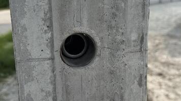 Concrete Hole A close up view of a circular hole drilled into a rough concrete surface offering a glimpse of a blurred background beyond. photo