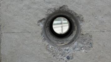 Concrete and Hole A close-up shot reveals the intricate texture and design of a weathered concrete pillar, highlighting a circular opening that draws the eye. photo