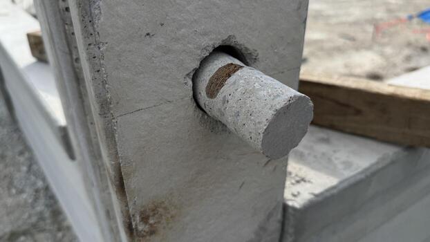 Construction Detail An up-close view captures the raw essence of building, focusing on the intricate connection between a concrete beam and a cylindrical concrete rod. photo