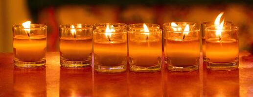 Wax with string in several small glasses was lit as a candle. photo