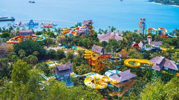 big colorful aquapark with slides and a swimming pool at the resort in summer. Entertainment park with water park by the sea on VinPearl Island in Nha Trang in Vietnam aerial top view from drone photo