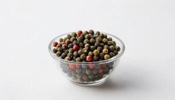 A clear bowl filled with a colorful assortment of peppercorns, suitable for culinary, food, spice, cooking, or gastronomy-related projects and advertisements. photo