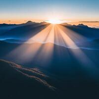 Sun rays shining over mountains in the morning photo