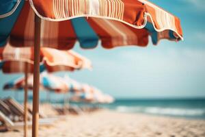 close up orange beach sun umbrella stands on sea shore, umbrellas and sun loungers on blurred background, concept of summer vacation, resort, weekend on hot day photo