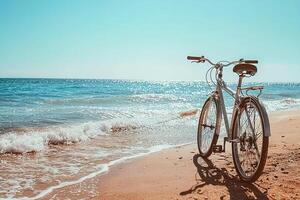 bicycle on sandy beach with ocean or sea waves and blue sky on background. coastal vibe, evoking freedom, simplicity, and joy of active outdoor leisure. photo