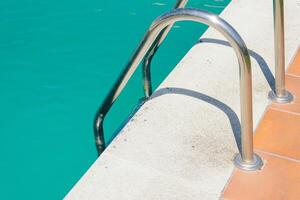 detail of a swimming pool edge ladder and water photo