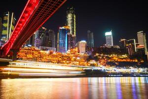Chongqing, China-APR 02, 2025- Night view Cityscape of the famous downtown shopping complex Hongyadong with illuminated bridge and highrise building in Chongqing, China photo