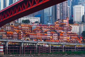Chongqing, China -APR 02, 2025- Twilight Cityscape of the famous downtown shopping complex Hongyadong with illuminated bridge and highrise building in Chongqing, China photo
