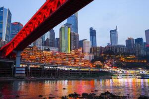 Chongqing, China-APR 02, 2025- Twilight Cityscape of the famous downtown shopping complex Hongyadong with illuminated bridge and highrise building in Chongqing, China photo