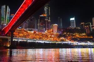 Chongqing, China- APR 02, 2025- Night view Cityscape of the famous downtown shopping complex Hongyadong with illuminated bridge and highrise building in Chongqing, China photo