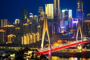 Chongqing, China - APR 02, 2025-Night view Cityscape of the famous downtown shopping complex and CBD with illuminated bridge and highrise building in Chongqing, China photo