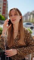 23 year old woman converses on her phone, displaying various expressions against an urban backdrop, highlighting communication and expression in a modern setting video