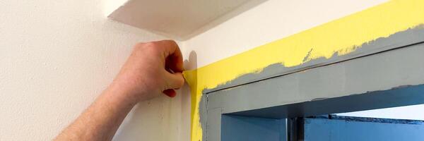 Hand peeling painters tape from a doorway, home renovation, DIY project, cleanliness, precision, Labor Day weekend preparation photo