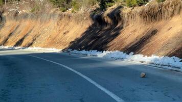 Winding mountain road with patches of snow, peaceful winter travel scene, adventure road trip concept, serene nature drive photo