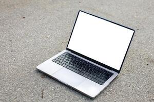 Open laptop with blank screen on pavement, concept of remote work, technology, digital workspace, innovation, and productivity photo