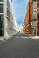 A Quiet Narrow Street in London Blends Modern and Traditional Architecture Under a Partly Cloudy Sky. photo
