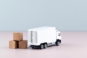 White toy truck with boxes on the light background, space for text. photo