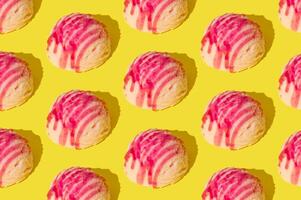 Pink strawberry ice cream pattern on yellow background. Summer food concept. Minimal isometric layout. Ice cream scoop aesthetic idea. photo