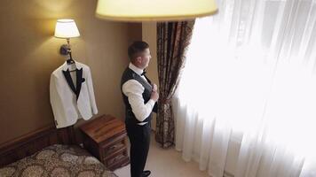 Groom buttoning jacket, man in suit fastens buttons on his jacket preparing to go out video