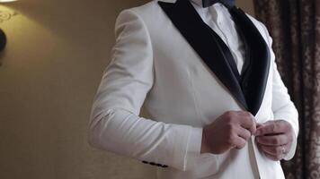 Groom buttoning jacket, man in suit fastens buttons on his jacket preparing to go out video
