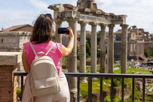 Capturing memories while overlooking ancient ruins in Rome during a sunny afternoon stroll photo