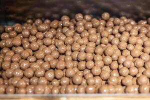 Production of shiny chocolate candies in a modern factory during daytime hours with a focus on quality and precision photo